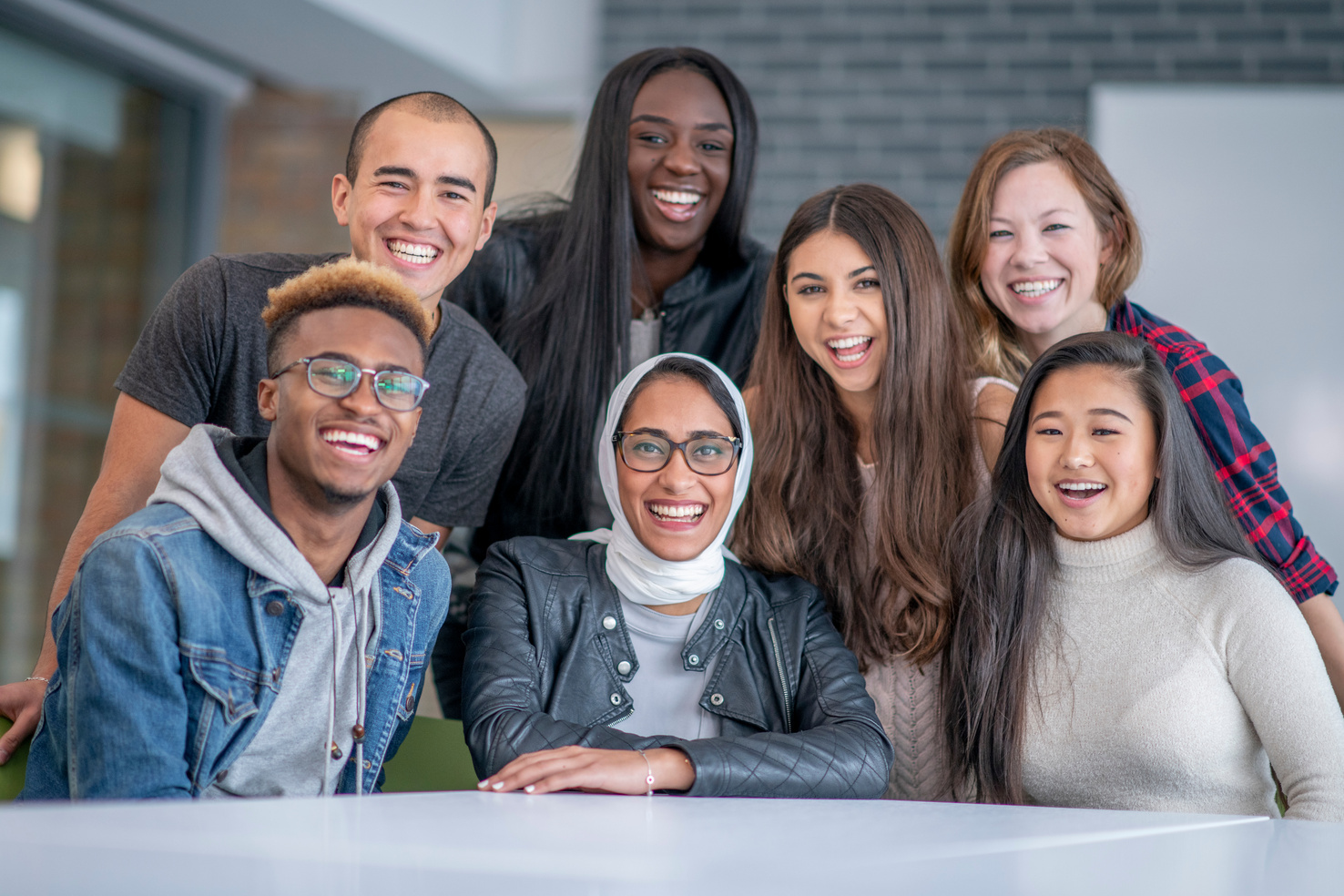 Photo of a diverse group of college students posing at a table.